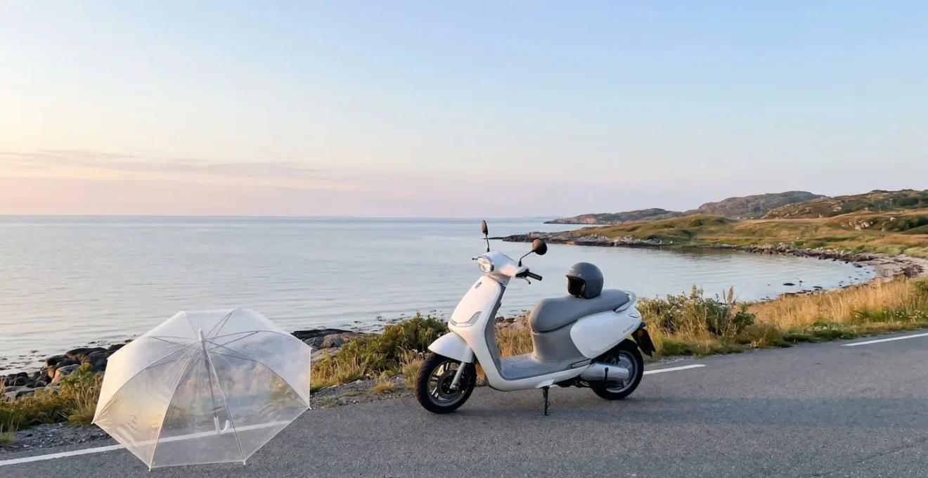 Scooter moderne garé sur route côtière au lever du soleil avec parapluie transparent au premier plan symbolisant la protection d'assurance